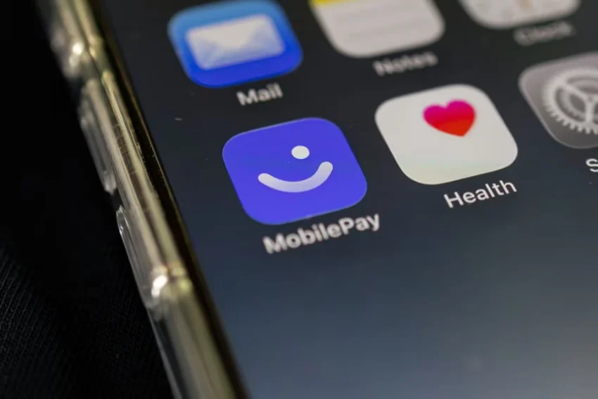 Det nye MobilePay-logo med en smiley på en iPhone